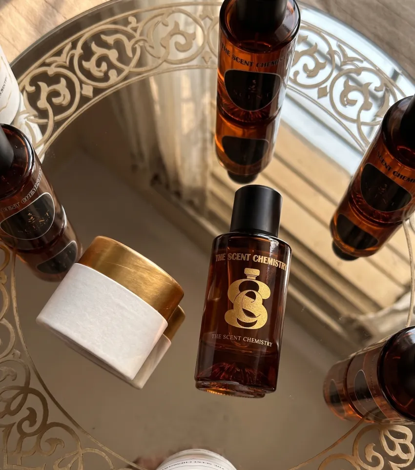 Amber perfume collection reflected in an ornate mirror